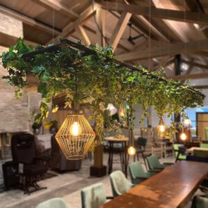 Zwart frame met bladeren erop en verschillende hang lampen eraan