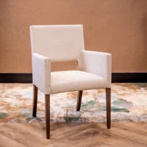 Stoel voor de zorg met houten poten en rond om gestoffeerd